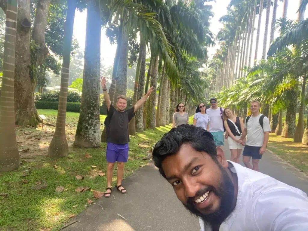 Guide and travellers on the royal palm avenue at the Royal Botanic Gardens, Peradeniya