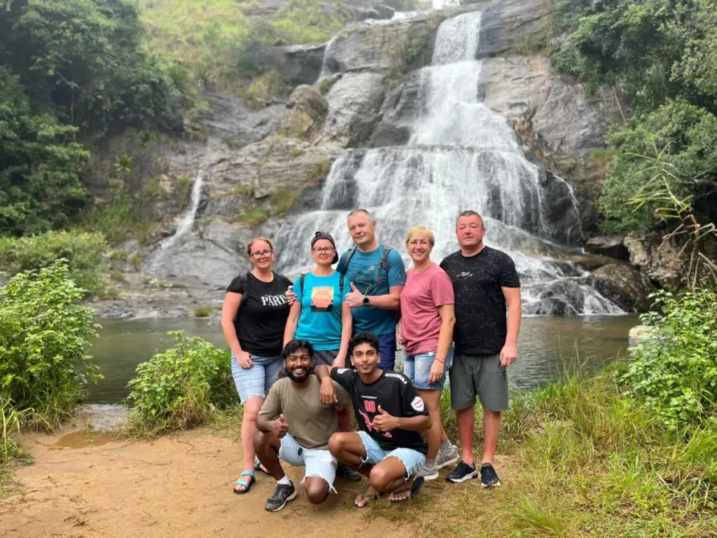 Oura Travel guests at a waterfall in the hill country