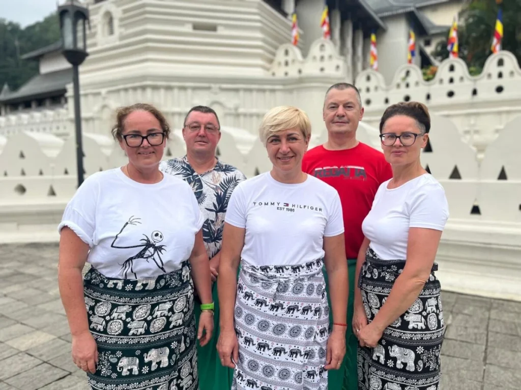 Travel group wearing sarongs outside the Temple of the Sacred Tooth Relic in Kandy