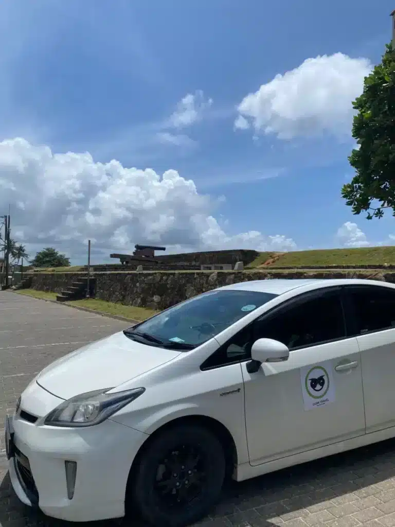 An Oura Travel car parked beside the water in Sri Lanka