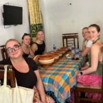 Five travellers seated at a village dining table before a Sri Lankan home cooked meal