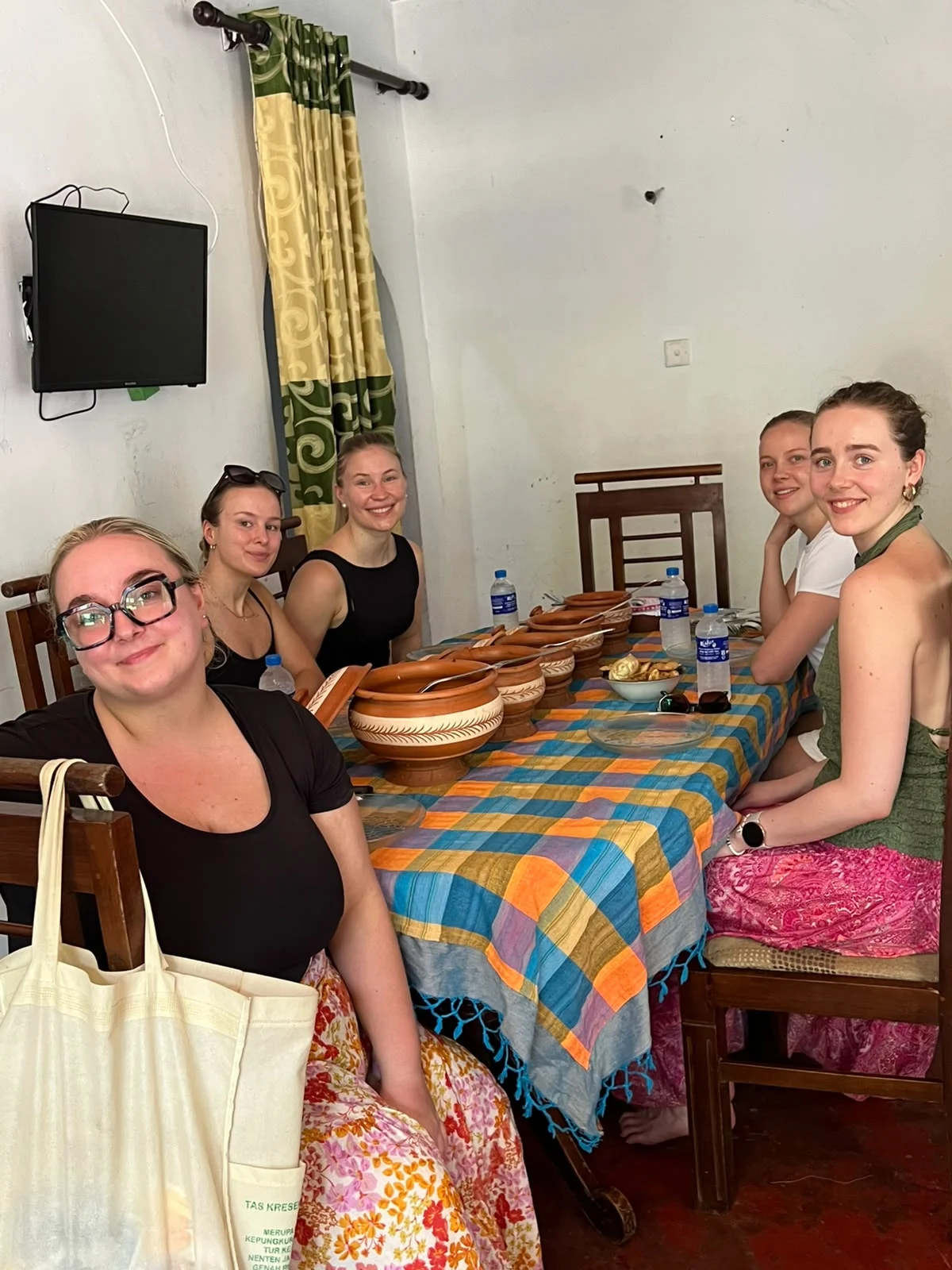Five travellers seated at a village dining table before a Sri Lankan home cooked meal