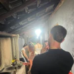 Guest smiling in a smoky traditional Sri Lankan kitchen during an evening cooking class