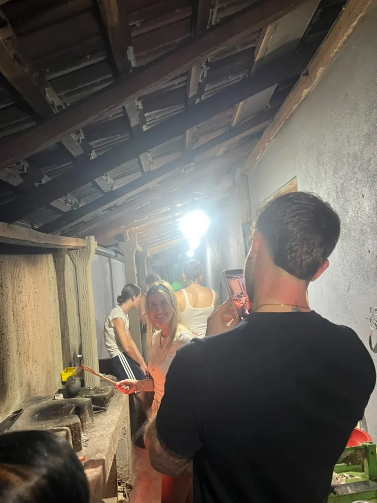 Guest smiling in a smoky traditional Sri Lankan kitchen during an evening cooking class
