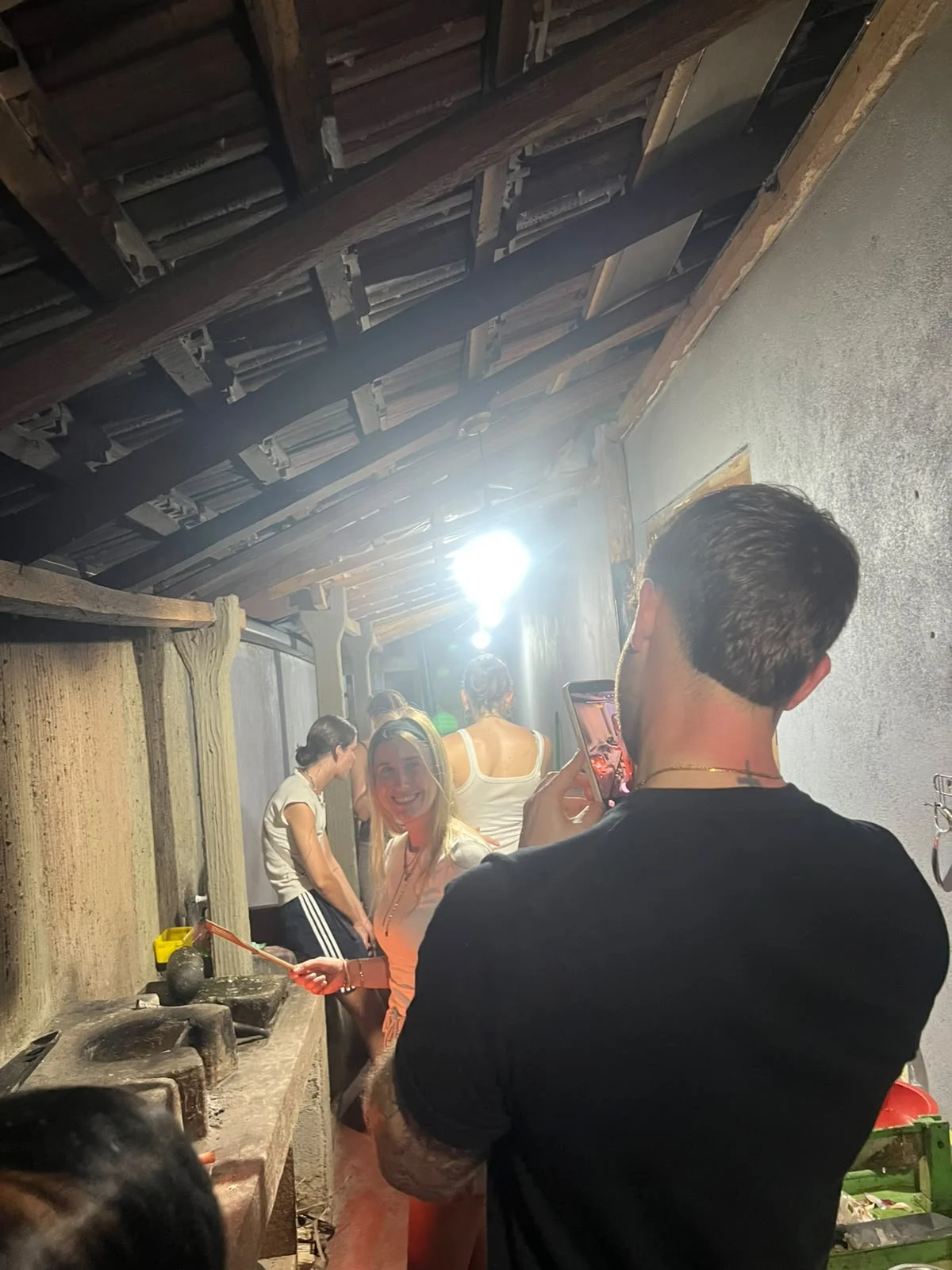 Guest smiling in a smoky traditional Sri Lankan kitchen during an evening cooking class