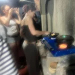 Traveller cooking over a stone hearth at a Sri Lankan village cooking class, clay pot heating over the fire