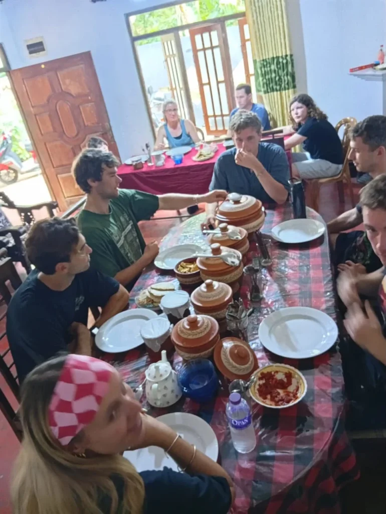 Group of travellers sharing a Sri Lankan rice and curry meal after a village cooking class